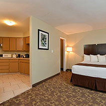 photo of king sized bed with a kitchen in a suite